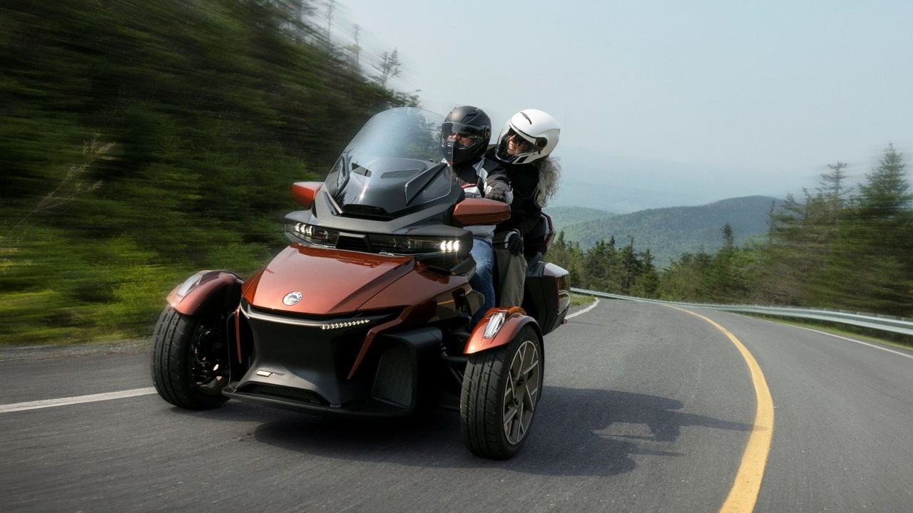 A couple riding a Can-Am Spyder RT 3-wheel motorcycle at high speed